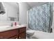 Neutral bathroom featuring a shower-tub combo with a blue patterned shower curtain and a wooden vanity at 43 Summerseat Way, Bunnlevel, NC 28323