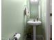 Half bath with pedestal sink and updated fixtures, powder room is painted a pleasing shade of green at 43 Summerseat Way, Bunnlevel, NC 28323