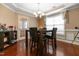 Elegant dining room with a modern chandelier, dark wood floors, and formal seating arrangement, ideal for entertaining at 43 Summerseat Way, Bunnlevel, NC 28323