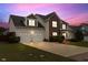 Charming two-story home showcasing a three-car garage, manicured lawn, and inviting front porch at sunset at 43 Summerseat Way, Bunnlevel, NC 28323