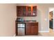 A built-in wet bar area with dark wood cabinets, a sink, a mini-fridge, and a microwave at 43 Summerseat Way, Bunnlevel, NC 28323