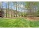 Spacious backyard featuring lush green lawn and mature trees offering privacy and shade at 4313 Branchwood Dr, Durham, NC 27705