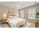 Sunlit bedroom featuring neutral walls, white bedding, and light wood furniture at 4313 Branchwood Dr, Durham, NC 27705