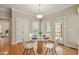 Charming breakfast nook with glass table, white chairs, and doors leading to the outdoor living area at 4313 Branchwood Dr, Durham, NC 27705