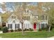 Inviting two-story home features a well-kept lawn, a vibrant red front door, and traditional black shutters at 4313 Branchwood Dr, Durham, NC 27705