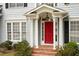 Inviting front entry with red door, white columns, brick steps, and manicured landscaping at 4313 Branchwood Dr, Durham, NC 27705