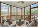 Relaxing screened porch with ceiling fan, wicker furniture, and views of the wooded backyard at 4313 Branchwood Dr, Durham, NC 27705