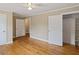 Bright bedroom features hardwood floors, neutral paint, ceiling fan, and an open closet at 4502 Mill Creek Rd, Cedar Grove, NC 27231