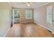 Cozy bedroom featuring hardwood floors, neutral paint, and natural light from two windows at 4502 Mill Creek Rd, Cedar Grove, NC 27231