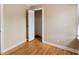 Bright bedroom featuring hardwood floors, neutral walls, and a closet with shutter doors at 4502 Mill Creek Rd, Cedar Grove, NC 27231