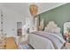 Bedroom with unique light fixture, boho seating, a dark green accent wall, and natural light at 472 Stonecrest Way, Pittsboro, NC 27312