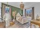This bedroom offers a bed with unique light fixture, seating and plenty of natural light at 472 Stonecrest Way, Pittsboro, NC 27312