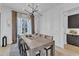 Elegant dining room with modern lighting, long wooden table, and ample seating at 472 Stonecrest Way, Pittsboro, NC 27312