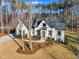 Charming white two-story house with a landscaped front yard surrounded by tall trees at 472 Stonecrest Way, Pittsboro, NC 27312
