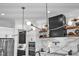 Open kitchen with stainless appliances, black range hood, and custom lighting fixtures at 472 Stonecrest Way, Pittsboro, NC 27312