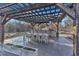 Outdoor kitchen under pergola featuring bar seating, dining area, and overhead fans at 472 Stonecrest Way, Pittsboro, NC 27312
