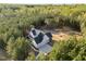 Expansive aerial view of a stunning home nestled amidst lush green trees, showcasing its secluded and peaceful setting at 494 Terry Rd, Hillsborough, NC 27278