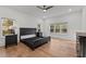 Relaxing primary bedroom boasts wood floors, recessed lighting, and serene views from the large windows at 494 Terry Rd, Hillsborough, NC 27278