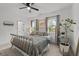 Bedroom with a black metal bed frame, neutral carpet, two windows, and tasteful decorations at 494 Terry Rd, Hillsborough, NC 27278