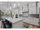Bright kitchen with white cabinets, a center island with seating, stainless appliances, and modern light fixtures at 494 Terry Rd, Hillsborough, NC 27278