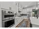 Kitchen with stainless steel appliances, gray tile backsplash, white cabinetry, and eat-in dining area at 494 Terry Rd, Hillsborough, NC 27278