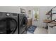 Well-equipped laundry room featuring new washer and dryer, window, storage cabinets, and unique rug at 494 Terry Rd, Hillsborough, NC 27278