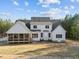 View of the rear of the house showcasing a screened-in porch and large windows overlooking a spacious yard at 494 Terry Rd, Hillsborough, NC 27278