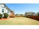 A spacious, grassy backyard featuring a wood fence, a porch, and lush greenery at 504 Prince Dr, Holly Springs, NC 27540