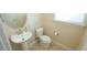 Powder room features pedestal sink, matching toilet and neutral paint at 504 Prince Dr, Holly Springs, NC 27540