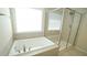 Bathroom with a large soaking tub, separate glass shower, and light tile at 504 Prince Dr, Holly Springs, NC 27540