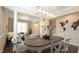 Elegant dining area featuring hardwood floors, modern lighting fixture, and white accents at 504 Prince Dr, Holly Springs, NC 27540