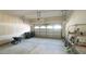 Spacious garage with door leading to the outside, storage shelves and wheelbarrow at 504 Prince Dr, Holly Springs, NC 27540