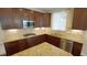 Well-lit kitchen features dark wood cabinetry, stainless steel appliances, and granite countertops at 504 Prince Dr, Holly Springs, NC 27540