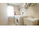 Convenient laundry room with a utility sink and shelving for storage at 504 Prince Dr, Holly Springs, NC 27540