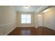 Well-lit room with hardwood floors, a window, and entrance door at 504 Prince Dr, Holly Springs, NC 27540