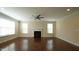 A spacious living room has hardwood floors, a ceiling fan, and a fireplace at 504 Prince Dr, Holly Springs, NC 27540