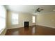 Open living room featuring a fireplace, ceiling fan, and large windows with plenty of sunlight at 504 Prince Dr, Holly Springs, NC 27540
