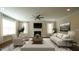 Staged living room with a fireplace, ceiling fan, hardwood floors, and neutral-toned furnishings at 504 Prince Dr, Holly Springs, NC 27540