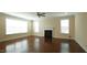 Bright living room with hardwood floors, fireplace, ceiling fan, and large windows at 504 Prince Dr, Holly Springs, NC 27540