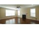 Bright living room with hardwood floors, fireplace, ceiling fan, and large windows at 504 Prince Dr, Holly Springs, NC 27540