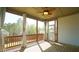 Relaxing screened-in porch featuring a ceiling fan, curtains, and a wooden floor overlooking a private wooded area at 504 Prince Dr, Holly Springs, NC 27540