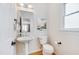 Cozy half-bathroom featuring a pedestal sink, stylish mirror, and a natural light filled window at 507 Parkside Cir, Chapel Hill, NC 27516