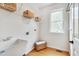 Functional laundry room with storage shelves, wash sink, and natural light at 507 Parkside Cir, Chapel Hill, NC 27516