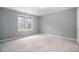 Carpeted bedroom features a large window for natural light at 537 Chatham Dr, Chapel Hill, NC 27516