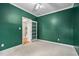 Bedroom featuring green walls, a white ceiling fan, and a glimpse of the hallway at 537 Chatham Dr, Chapel Hill, NC 27516