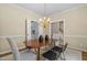 Formal dining room with modern light fixture, stylish chairs, and views of the entryway and kitchen at 537 Chatham Dr, Chapel Hill, NC 27516