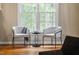 Bright sitting area featuring hardwood floors, a large window view, and stylish accent chairs at 537 Chatham Dr, Chapel Hill, NC 27516