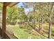 A view from the deck overlooks the fenced-in backyard with grass and mature trees at 5612 Crossfield Dr, Raleigh, NC 27613