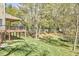 A view of the deck from the side yard with mature trees and foliage at 5612 Crossfield Dr, Raleigh, NC 27613