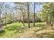 Wide-angle view of the large backyard and deck, surrounded by a wooden fence and mature trees at 5612 Crossfield Dr, Raleigh, NC 27613